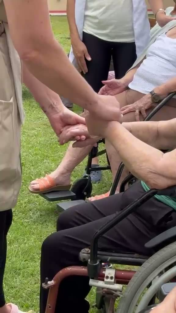 Profissional auxiliando idosa na mobilidade com cadeira de rodas